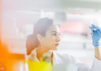Serious chemist holding test tube in laboratory