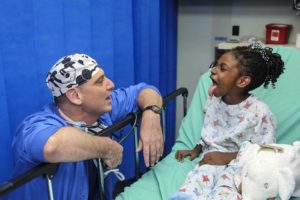 Child pulling silly face at medical personel